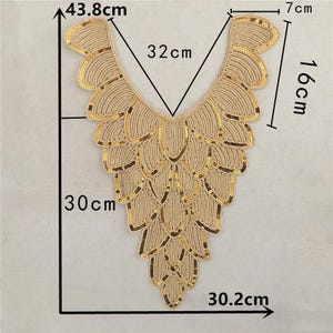 Puede incluir: Adorno de tela con lentejuelas doradas con diseño de cuello en V. El adorno mide 32 cm de ancho, 16 cm de alto y 30 cm de largo.