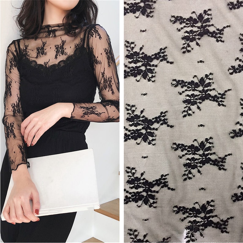 May include: Black sheer lace fabric with a floral pattern. The lace is delicate and has a soft, flowing texture.