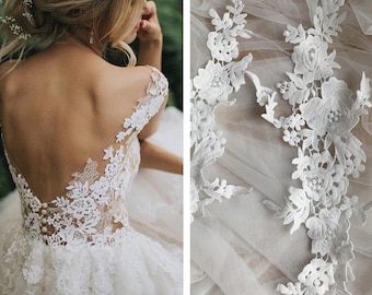 Puede incluir: Un vestido de novia blanco con un corpiño de encaje y una falda de tul. La parte posterior del vestido presenta una espalda baja con una superposición de encaje. El vestido se muestra con una superposición de tela de encaje blanco.