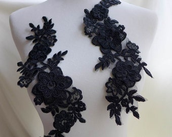 Puede incluir: Dos aplicaciones de encaje floral negro con delicados diseños florales. Las aplicaciones están hechas de una tela transparente con detalles intrincados.