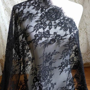 May include: Black lace fabric with a floral pattern. The lace has a scalloped edge.