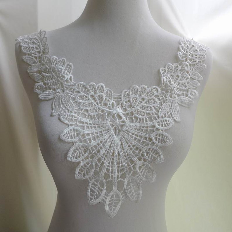 Pu&ograve; includere: Bordino in pizzo bianco con un bordo smerlato e un delicato motivo floreale. Questo bordino &egrave; perfetto per aggiungere un tocco di eleganza a qualsiasi progetto.