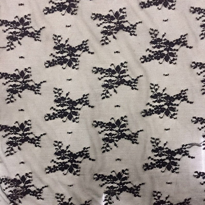 May include: Black lace fabric with a repeating floral pattern.