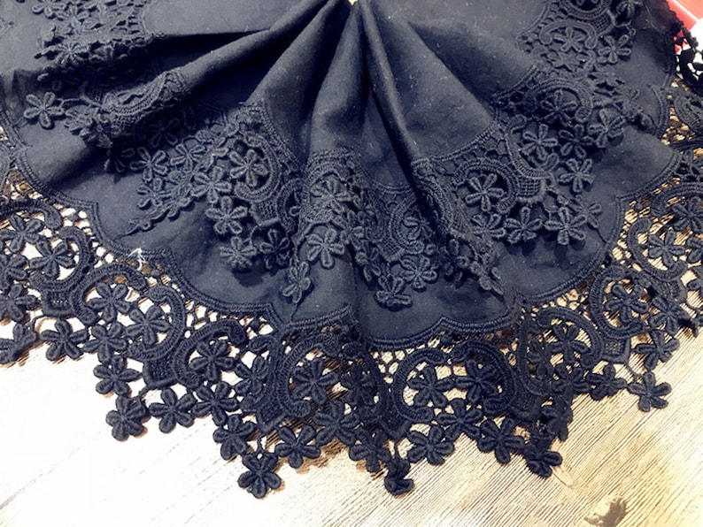 May include: Black lace trim with a scalloped edge. The lace is made of delicate floral patterns.