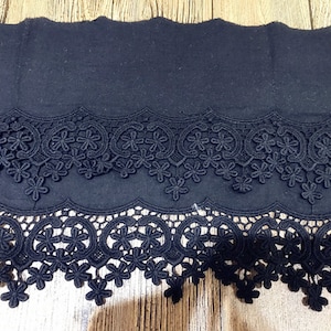 May include: Black lace trim with two rows of delicate floral designs. The trim is made of a soft, lightweight material and has a scalloped edge.