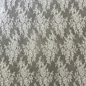 May include: White floral lace fabric with a scalloped edge. The lace has a delicate floral pattern and is perfect for crafting, sewing, and decorating.