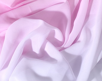 Könnte beinhalten: Ein weicher, rosa-weißer Ombre-Stoff mit einer glatten, seidenartigen Textur. Der Stoff ist drapiert und gefaltet und erzeugt einen fließenden und eleganten Look.