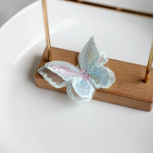 May include: A light blue iridescent butterfly applique with a delicate lace design.