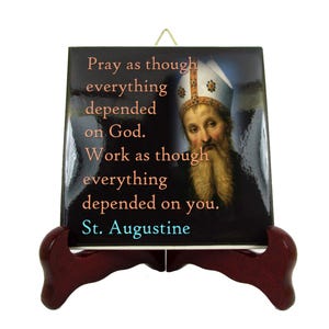 May include: A ceramic tile with a quote by Saint Augustine: "Pray as though everything depended on God. Work as though everything depended on you." The tile features a portrait of Saint Augustine and a dark blue background.