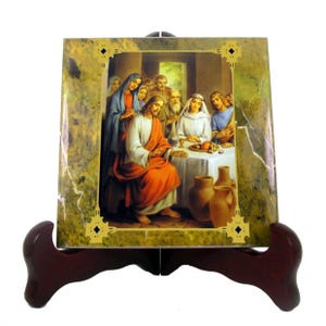 May include: A ceramic tile with a green marble background and a gold frame. The tile features a painting of Jesus and his disciples at the Last Supper. The painting is in a realistic style and depicts the scene in a warm, inviting setting.