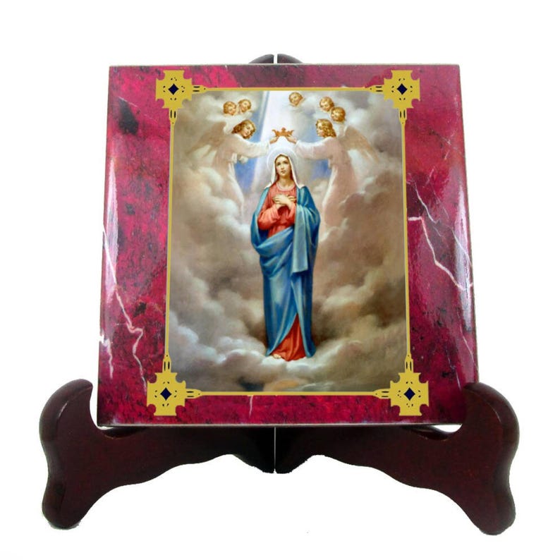May include: A ceramic tile featuring a religious image of the Virgin Mary in a blue robe, surrounded by clouds and angels. The tile is framed with a gold border and has a red marble background.