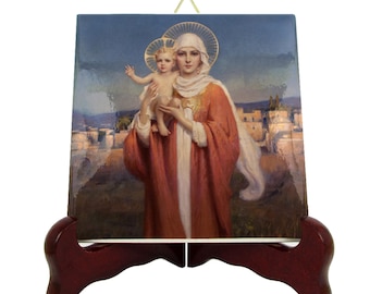 May include: A ceramic tile with a painting of the Virgin Mary holding the baby Jesus. The painting is in a traditional style with a blue background and a gold halo around the Virgin Mary's head. The tile is on a wooden stand.