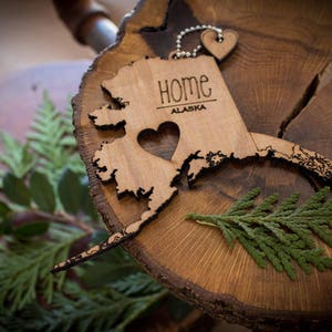 All US State Ornaments. Heart & Home. Show love for the place that stole your heart with these Ornaments, Keychains, and tokens of love Alaska