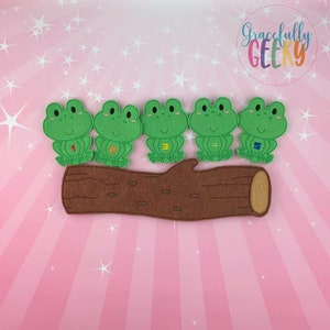May include: Five green felt frog figures with numbers 1-5 sit on a brown felt log. The background is pink with white starbursts and the text "Gracefully Geeky" in a colorful circle.