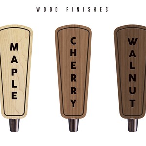 May include: Three wooden beer tap handles with different wood finishes: maple, cherry, and walnut. Each handle has the wood type written vertically on the front.