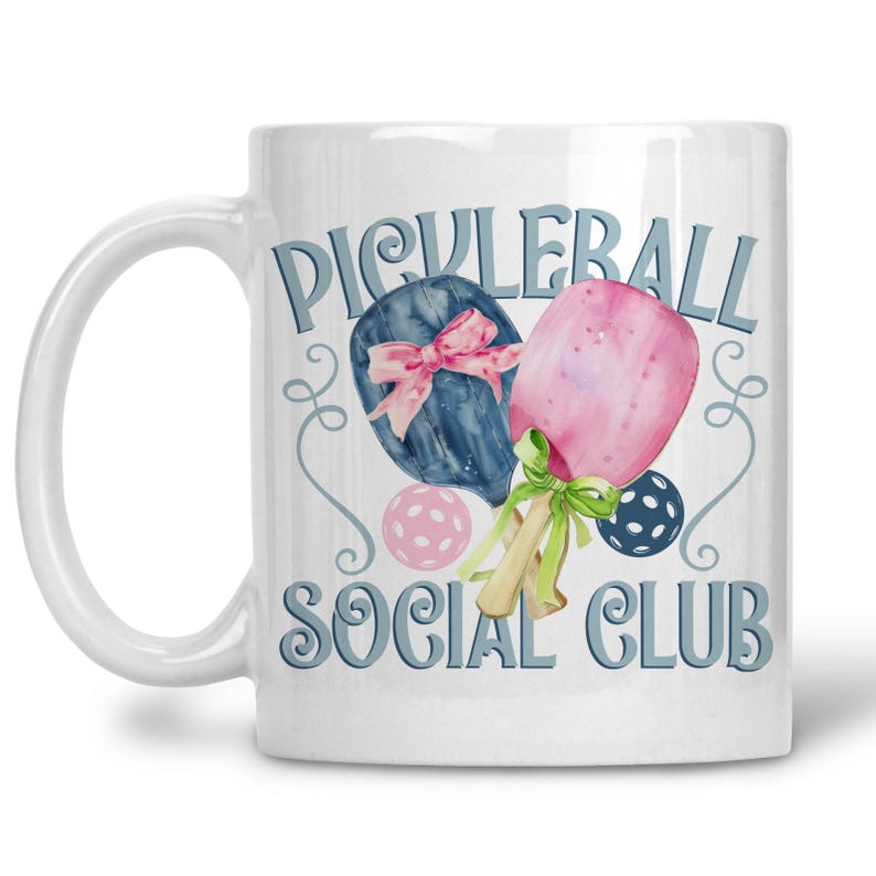 May include: White ceramic mug with a watercolour design. The mug features the text "Picklerball Social Club" and illustrations of pickleball paddles, balls, and decorative swirls in blue, pink, and green.