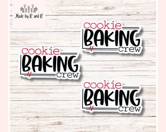 Może przedstawiać: Trzy białe naklejki z napisem "cookie BAKING crew" w kolorze czarnym i czerwonym. Naklejki są prostokątne z czarną obwódką i znajdują się na jasnym tle z usłojeniem drewna. W lewym górnym rogu znajduje się napis "Made by R and R".