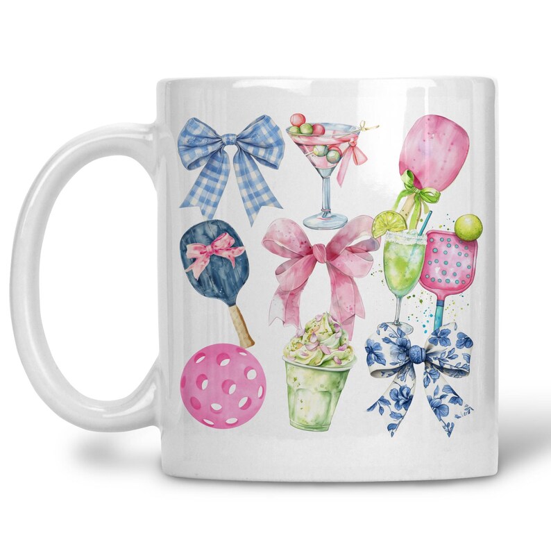 May include: White ceramic mug with a watercolour design of bows, martini glasses, pickleball paddles, and a pickleball ball. The design includes pink, blue, and green elements, creating a playful and sporty theme.