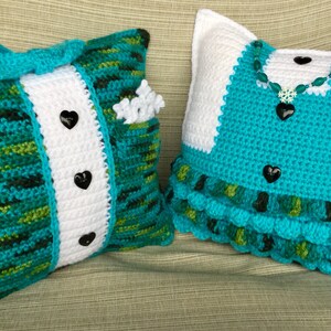 May include: Two crocheted pillows, one with a tuxedo design in green, white, and black, and the other with a dress design in turquoise, white, and green.
