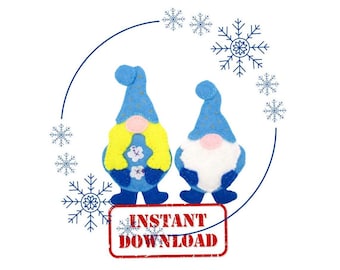 May include: Two blue felt gnomes with white beards and hats. The gnome on the left has yellow hair and a floral design on its chest. The gnome on the right has a white beard and a pink nose. The gnomes are surrounded by blue snowflakes.