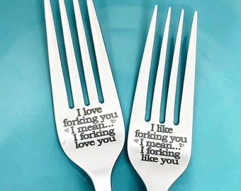 May include: Two stainless steel forks with engraved text. One fork reads "I love forking you... I mean... I forking love you." The other fork reads "I like forking you... I mean... I forking like you."