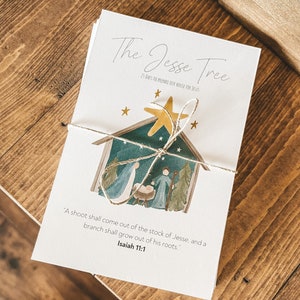 May include: A white card with the text "The Jesse Tree 25 Days to Prepare Our House for Jesus" and a watercolour illustration of a nativity scene with a star above. The text "A shoot shall come out of the stock of Jesse, and a branch shall grow out of his roots." Isaiah 11:1 is printed below the illustration.