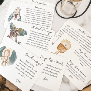 Puede incluir: Conjunto de diez tarjetas blancas con ilustraciones y texto coloridos. Las tarjetas presentan oraciones y citas religiosas, incluyendo los Diez Mandamientos, Memorare, la oraci&oacute;n de San Miguel, &Aacute;ngel de la Guarda, Oraci&oacute;n antes de las comidas, Oraci&oacute;n despu&eacute;s de la comuni&oacute;n y el Credo de los Ap&oacute;stoles.