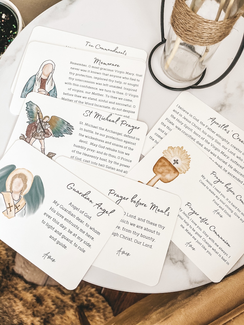 Puede incluir: Conjunto de diez tarjetas blancas con ilustraciones y texto coloridos. Las tarjetas presentan oraciones y citas religiosas, incluyendo los Diez Mandamientos, Memorare, la oraci&oacute;n de San Miguel, &Aacute;ngel de la Guarda, Oraci&oacute;n antes de las comidas, Oraci&oacute;n despu&eacute;s de la comuni&oacute;n y el Credo de los Ap&oacute;stoles.