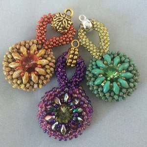 May include: Five beaded pendants with different colors and designs. The pendants are made with small beads in various colors, including orange, yellow, green, purple, and turquoise. Each pendant has a different design, including a circle, a flower, and a teardrop shape. The pendants are attached to gold and silver jump rings.