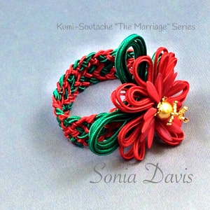 May include: A red and green braided bracelet with a red flower accent and a gold bead in the center. The bracelet is labeled "Kumi-Soutashe "The Marriage" Series" and "Sonia Davis".