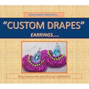 May include: A pair of pink and green beaded earrings with a light blue crystal accent. The earrings are shaped like a fan and have a fringe design.
