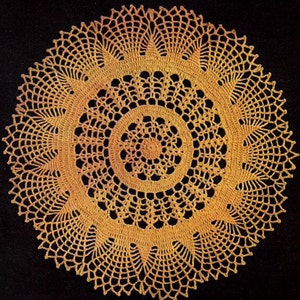 Puede incluir: Un encaje de ganchillo de color amarillo dorado con un diseño circular. El encaje tiene un patrón delicado e intrincado con múltiples capas de puntadas de ganchillo.