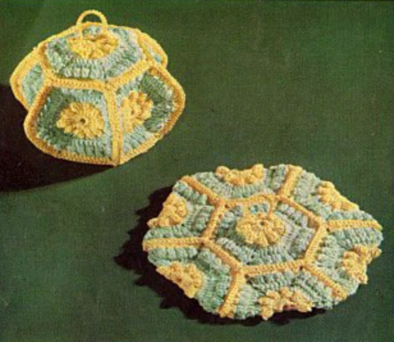 May include: Two crocheted pot holders in a green and yellow color scheme. The pot holders are shaped like hexagons and have a raised, textured design.