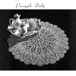 May include: A white crocheted doily with a pineapple design. The doily is on a black background and has a set of teacups and a teapot on top of it. The text "The Large Big Pineapple Doily" is at the top of the image.