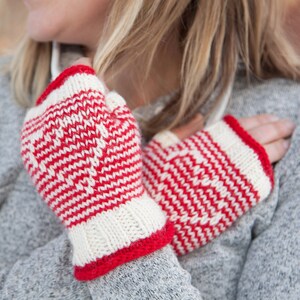 May include: A pair of red and white striped fingerless gloves. The gloves are knitted and have a white background with red stripes.