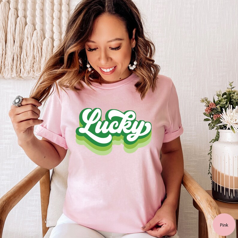 May include: A pink t-shirt with a green retro-style "Lucky" graphic.