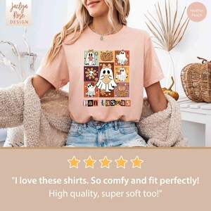 K&ouml;nnte beinhalten: Ein pinkfarbenes T-Shirt mit einem grafischen Design aus Geistern und K&uuml;rbissen, die in einem Raster angeordnet sind. Der Text "Pantasmas" ist unter dem Design gedruckt.