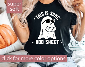 May include: A black t-shirt with a white ghost wearing sunglasses and sticking its tongue out. The text on the shirt says "This is some Boo Sheet."