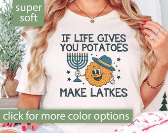 May include: White t-shirt with a graphic of a potato holding a menorah and the text "If life gives you potatoes make latkes".