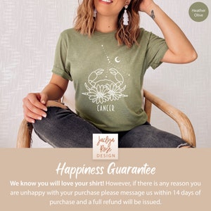 May include: A green t-shirt with a white outline of a crab with flowers around it. The text "CANCER" is below the crab. The text "Jaclyn Rose DESIGN" is at the bottom of the image. The text "Happiness Guarantee" is at the bottom of the image. The text "We know you will love your shirt! However, if there is any reason you are unhappy with your purchase please message us within 14 days of purchase and a full refund will be issued." is at the bottom of the image.