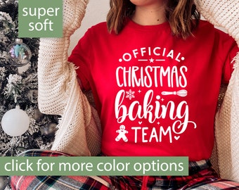 May include: Red t-shirt with white text that says "Official Christmas Baking Team" with a gingerbread man, snowflake, and whisk graphic. The shirt is super soft.