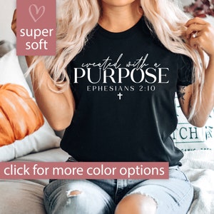 May include: Black t-shirt with white text that reads "created with a PURPOSE EPHESIANS 2:10" and a small white cross.