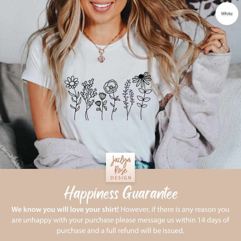 May include: White t-shirt with a black line drawing of a row of flowers. The text "Jaclyn Rose DESIGN" is on the bottom of the shirt. The text "Happiness Guarantee" is on a tan background below the shirt. The text "We know you will love your shirt! However, if there is any reason you are unhappy with your purchase please message us within 14 days of purchase and a full refund will be issued." is below the text "Happiness Guarantee."