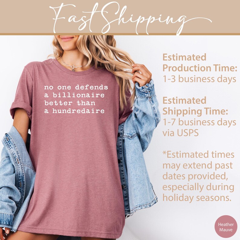 K&ouml;nnte beinhalten: Ein T-Shirt in Heide-Mauve mit dem Text "no one defends a billionaire better than a hundredaire" in wei&szlig; gedruckt. Das T-Shirt wird von einer Person in einer Jeansjacke getragen.