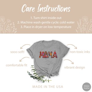 May include: A gray t-shirt with the word "MAMA" printed in colorful, intricate lettering. The shirt is made in the USA and features a comfortable fit, soft fabric, and non-toxic inks. Care instructions are provided for washing and drying the shirt.