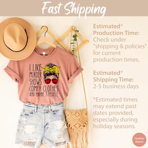 May include: A pink t-shirt with a graphic of a woman wearing sunglasses and a yellow headband with the text "I like murder shows, comfy clothes and maybe 3 people".