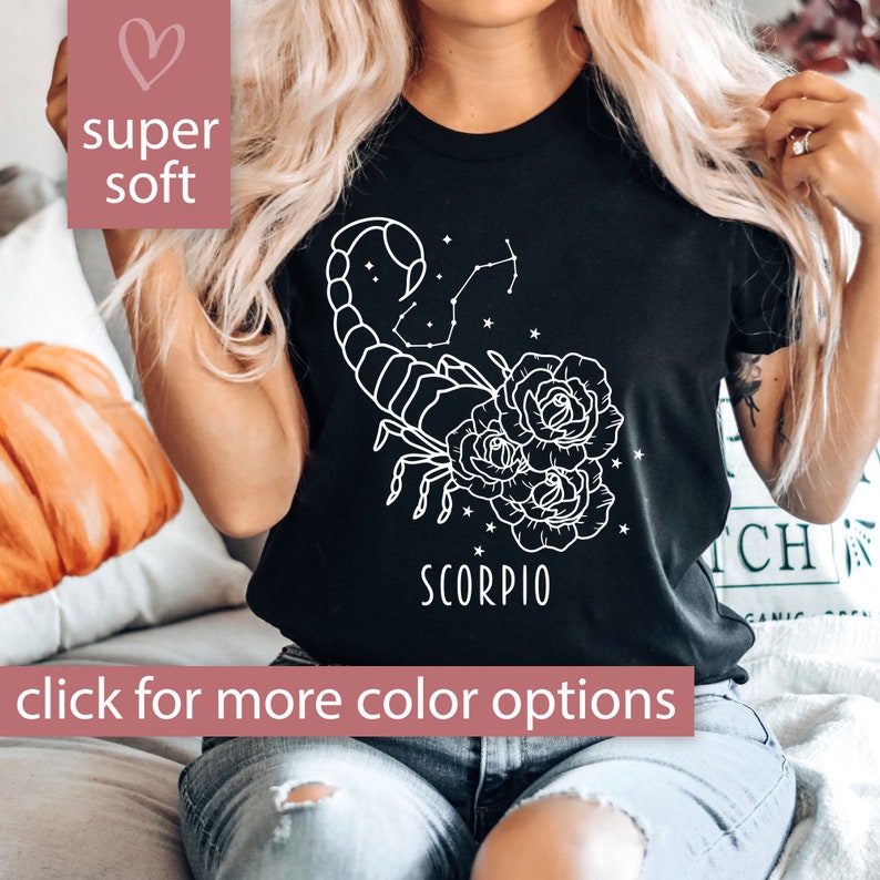 Pu&ograve; includere: Maglietta nera con un contorno bianco di uno scorpione con fiori e la parola "Scorpio" stampata sul davanti.
