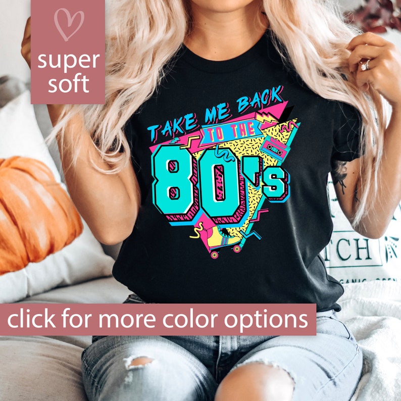 Pu&ograve; includere: Maglietta nera con una stampa grafica in stile retr&ograve; anni '80. La grafica presenta il testo "Take Me Back to the 80's" in rosa e blu con un pattino a rotelle e un nastro per cassette.