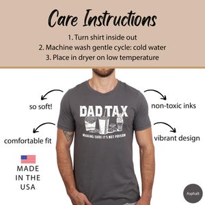 K&ouml;nnte beinhalten: Ein graues T-Shirt mit einer wei&szlig;en Grafik, auf der "Dad Tax" steht und ein Cartoon-Bild von Fast Food abgebildet ist. Der Text unter dem Bild lautet "Making sure it's not poison".