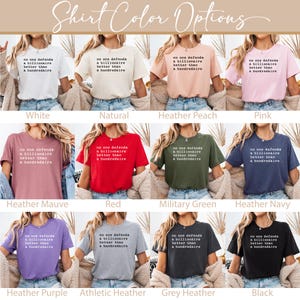 K&ouml;nnte beinhalten: Ein Grafik-T-Shirt-Design mit dem Text "No one defends a billionaire better than a hundredaire" auf 10 verschiedenen farbigen Shirts. Die Shirts werden auf Models gezeigt, die sie tragen. Die Farben sind wei&szlig;, natur, heide-pfirsich, rosa, heide-mauve, rot, milit&auml;rgr&uuml;n, heide-marine, heide-lila, sportlich-grau, grau-meliert und schwarz.